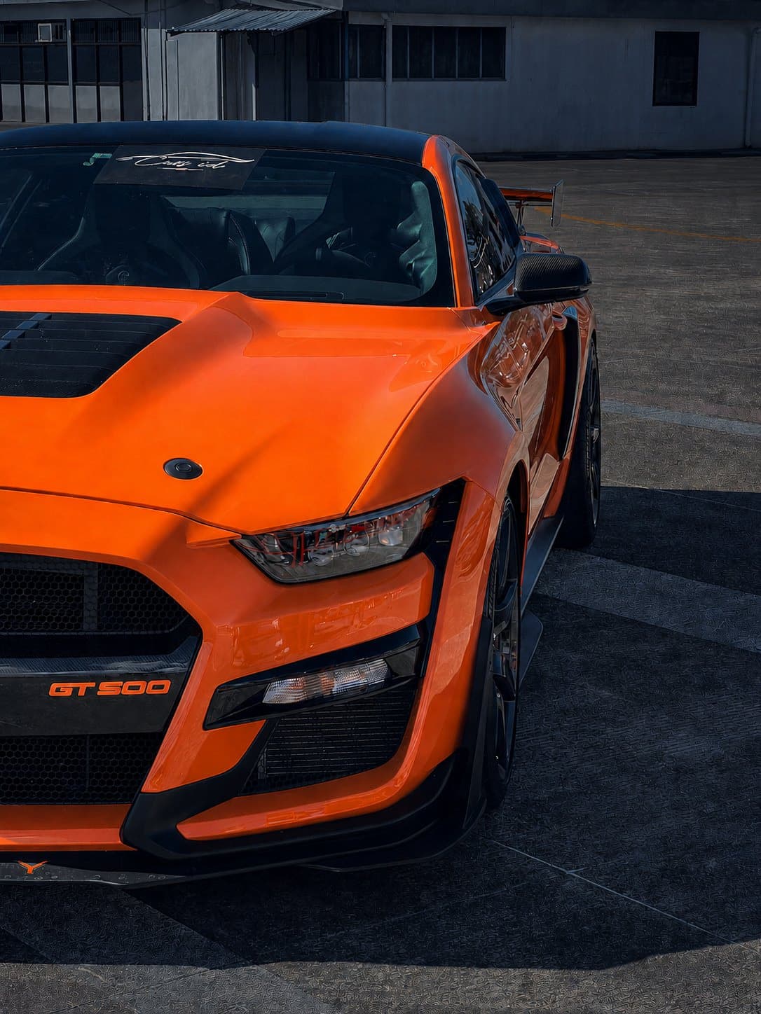 Frontal de un Shelby GT500 naranja, fotograma de una pieza vertical.