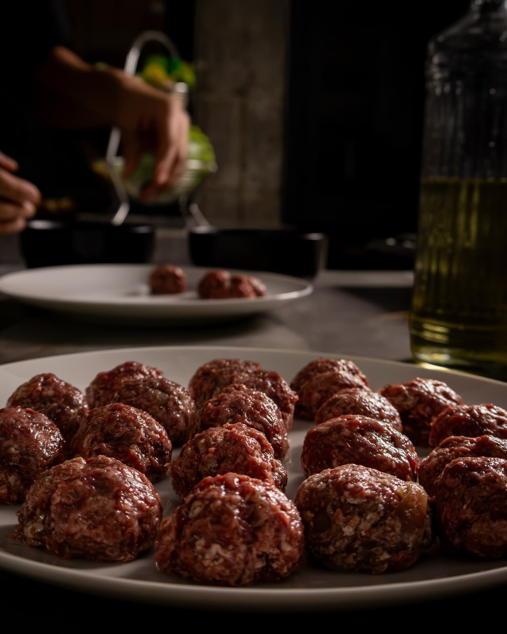 Albóndigas en preparación sobre plato blanco.